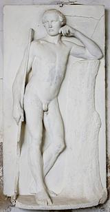 Stephan Ussing. Nøgen ung mand, der holder en stav og støtter mod en træstamme | RKM